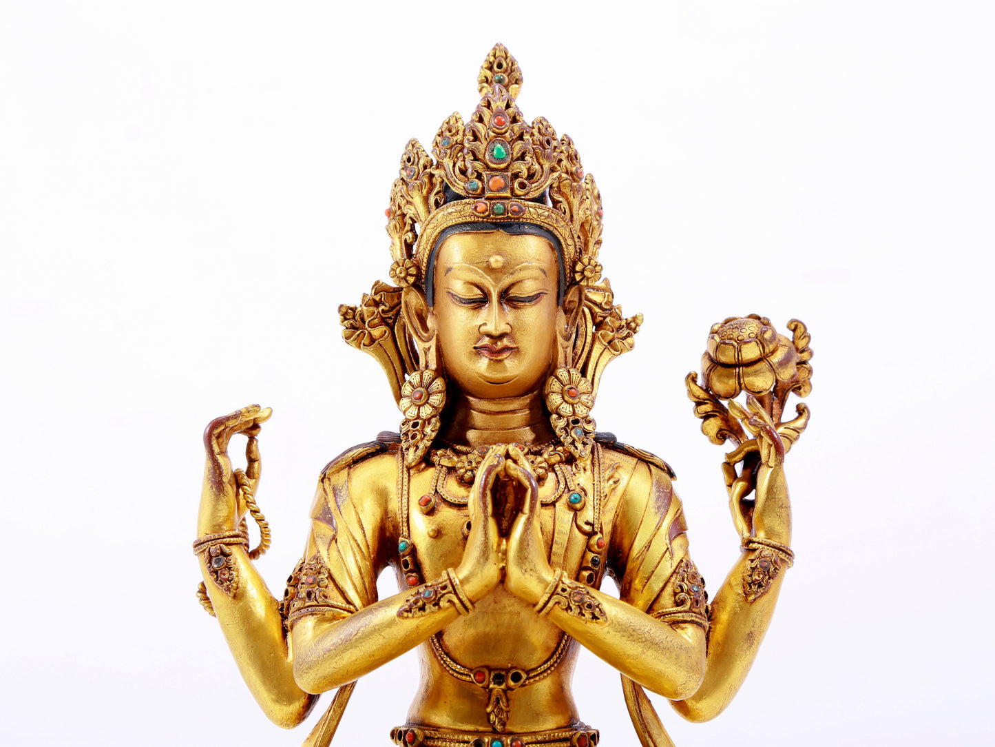 A solemn gilt bronze statue of Guanyin with four arms inlaid with hundreds of treasures