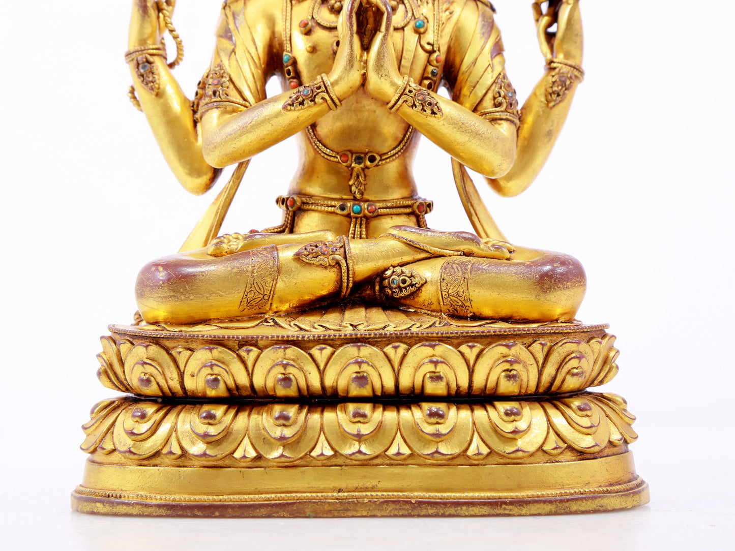 A solemn gilt bronze statue of Guanyin with four arms inlaid with hundreds of treasures