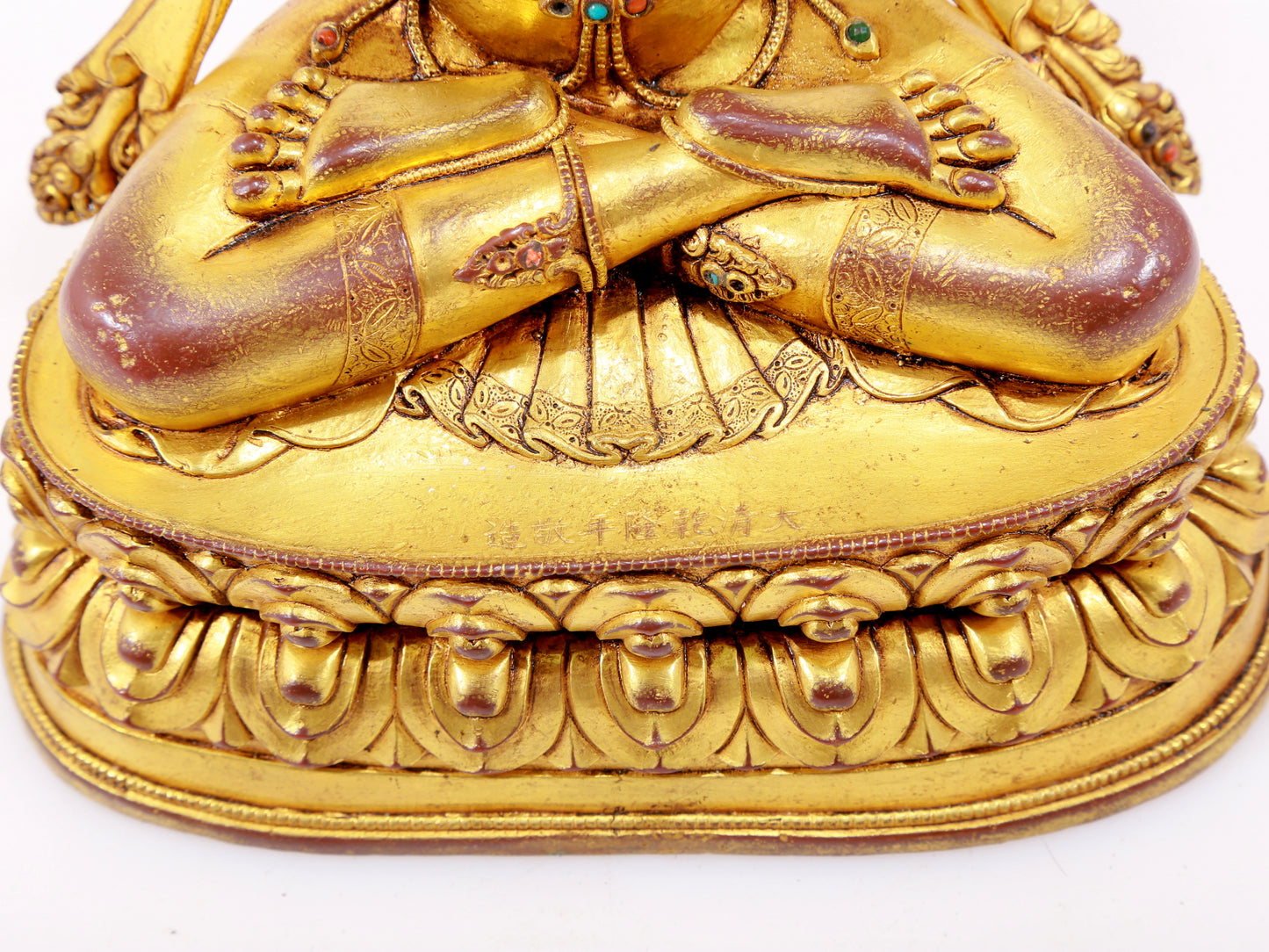 A solemn gilt bronze statue of Guanyin with four arms inlaid with hundreds of treasures