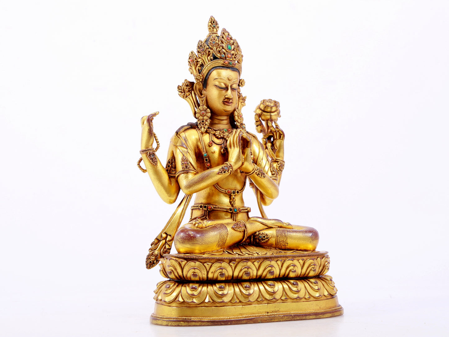 A solemn gilt bronze statue of Guanyin with four arms inlaid with hundreds of treasures