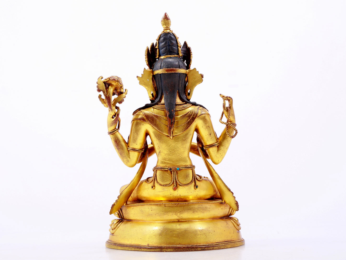 A solemn gilt bronze statue of Guanyin with four arms inlaid with hundreds of treasures