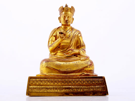 A solemn gilt bronze statue of the Guru