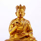 A solemn gilt bronze statue of the Guru