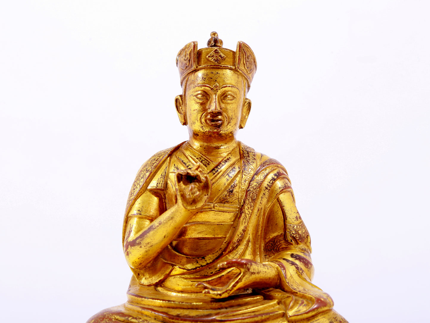 A solemn gilt bronze statue of the Guru