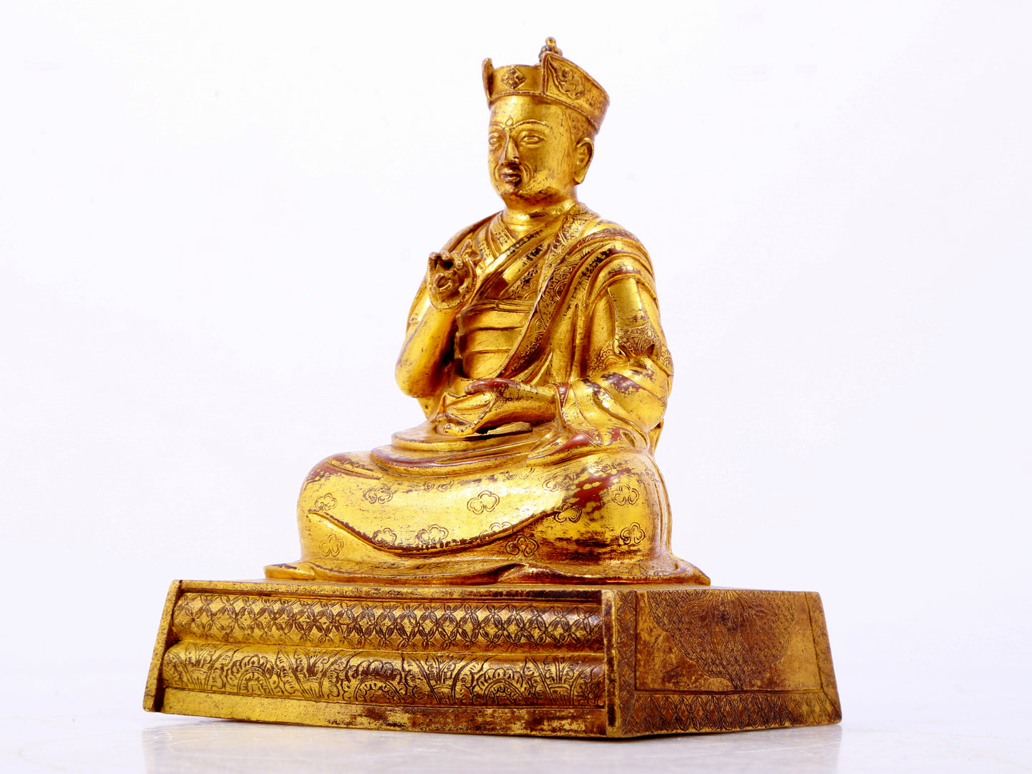 A solemn gilt bronze statue of the Guru