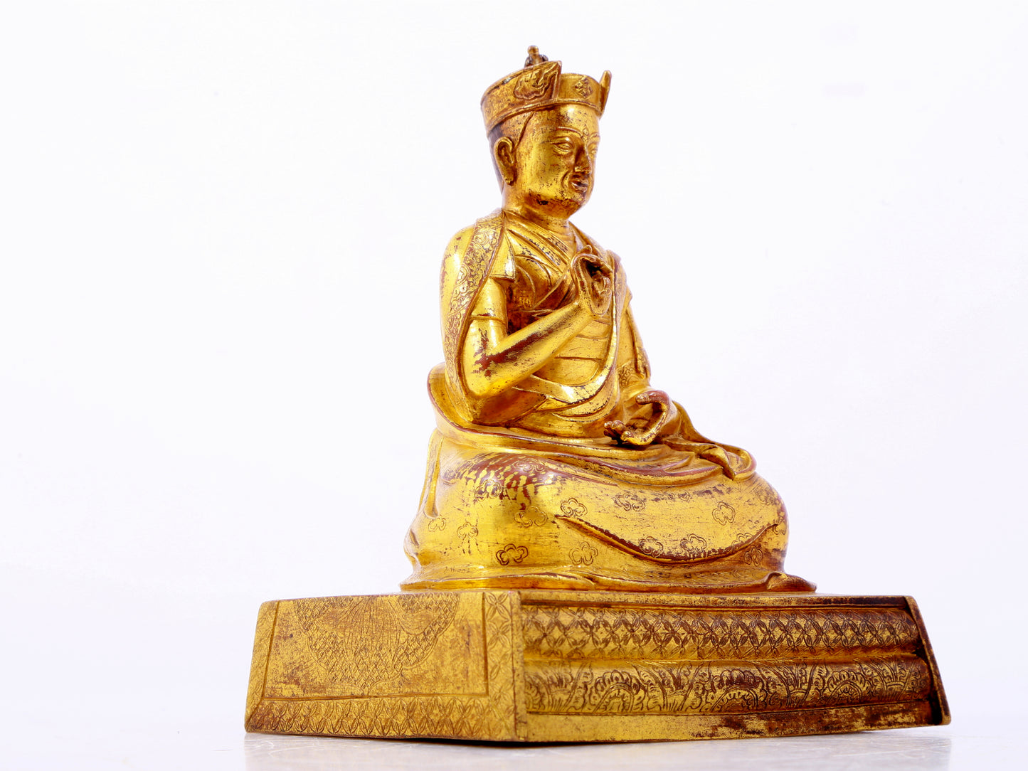 A solemn gilt bronze statue of the Guru